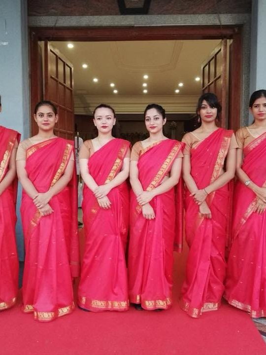 EventEdge wedding hostesses in sari uniform standing at a venue entrance